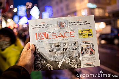 Man holding L`Alsace French newspaper at press kiosk announcing the death of Editorial Stock Photo