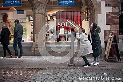 Chinese tourists watching in a binoculars in the street Editorial Stock Photo