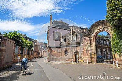 Rear view of single mother on bicycle with kid chair on the tiny French street Editorial Stock Photo