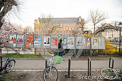 Adult woman walking near all candidate electoral campaign poster near polling Editorial Stock Photo
