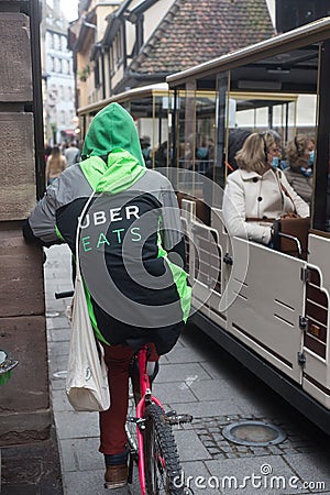 Portrait on back view of Uber eats delivery man with uber eats vest on a bicycle in the street Editorial Stock Photo