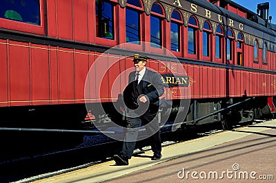 Strasburg, PA: Conductor and Railroad Cars Editorial Stock Photo
