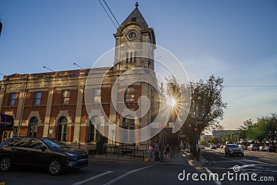 Strathcona Public Building - an old brick house with a tower and clock. Old post office. Amazing sunset, sun rays, clear sky. Stock Photo