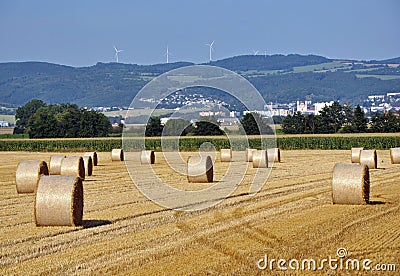 Straw bales in the field under Å ternberk, on the horizon of a wind turbine. Czech Republic. Stock Photo