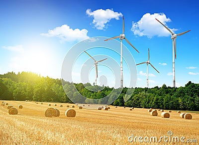 Straw bales with wind turbines Stock Photo