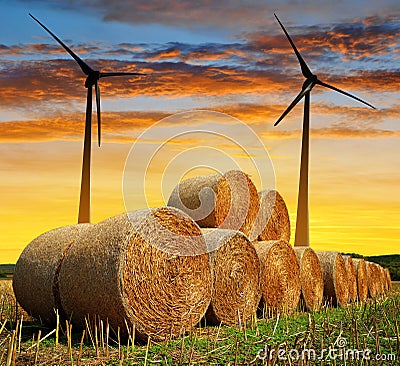 Straw bales with wind turbines Stock Photo