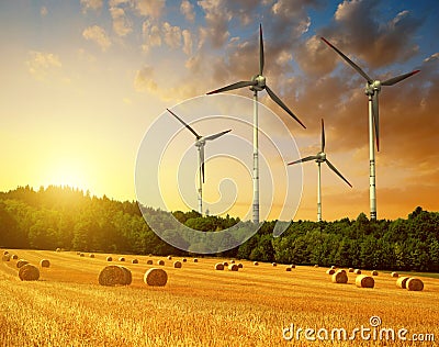 Straw bales with wind turbines on farmland Stock Photo