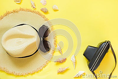 Straw beach foman`s hat, black sun glasses with retro camera on yellow background. Top view. Flat lay. Space for text. Travel con Stock Photo