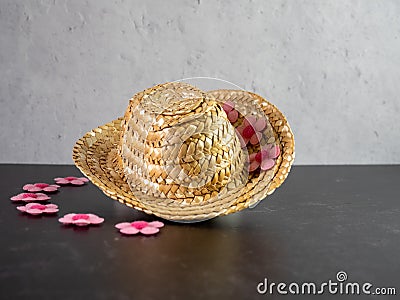 Straw Cowgirl Hat with pink felt flowers on a plaster and black slate background Stock Photo