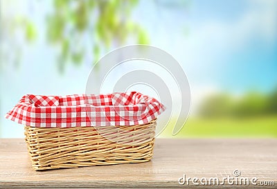Straw empty basket decorated with picnic checkered cloth nature background Stock Photo