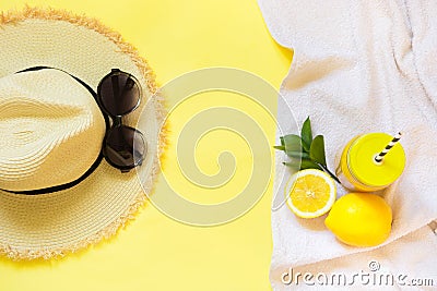 Straw foman`s hat, sun glasses and beach accessory with detox citrics water on yellow. Top view. Flat lay. Stock Photo