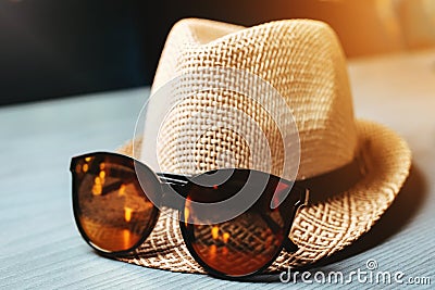 Straw hat with sunglasses on the table. Summer atmosphere. Stock Photo