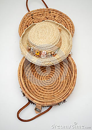 Straw hat trimmed in dried flowers on top of woven basket Stock Photo