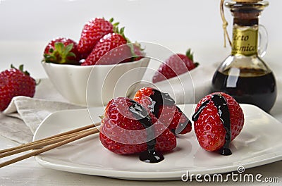 Strawberries with balsamic vinegar drops behind with whole strawberries Stock Photo