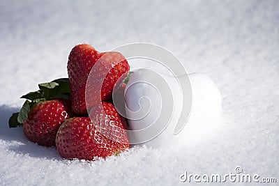 Strawberries and Snow Hearts Shape on White Snow Background Stock Photo