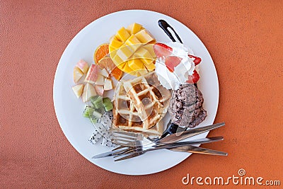 strawberry apple mango orange kiwi waffle with chocolate ice cream and whip cream Stock Photo