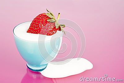 Strawberry in blue cup with yogurt spill Stock Photo