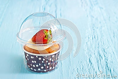 Strawberry cup cake on blue paint wooden background, soft and blur Stock Photo