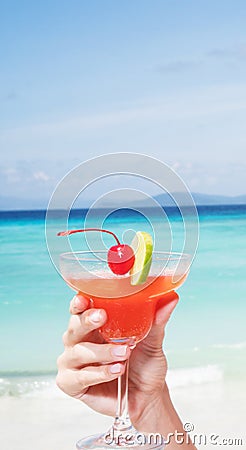 Strawberry Daiquiri cocktail in woman`s hand at the beach restaurant Stock Photo