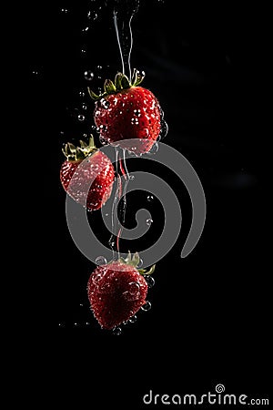 Strawberry Fall In Water, Red Fruit Splash, Juicy Strawberry Falling With Splash on Black Background Stock Photo