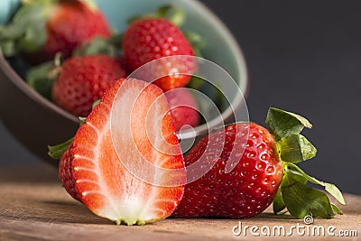 The strawberry and a half, in the background a tilted bowl Stock Photo