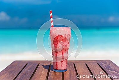 Strawberry Frappuccino drink with straw on wooden table ocean background at the beach Stock Photo