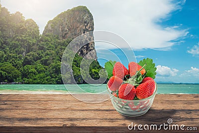 Strawberry Glass on wooden desk and beach side background Stock Photo