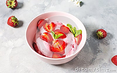 Strawberry ice cream in a bowl with strawberries on a concrete background Stock Photo