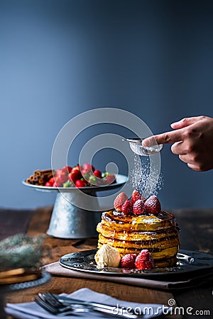 Strawberry pancakes with maple syrup.Sprinkle with powdered sugar on top. Stock Photo