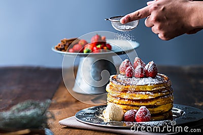 Strawberry pancakes with maple syrup.Sprinkle with powdered sugar on top. Stock Photo