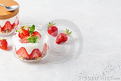 Strawberry parfait with yogurt and granola in glass jar. Healthy breakfast recipe. Summer dessert concept Stock Photo