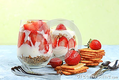 Strawberry yogurt with berries French cracker and muesli on a bright table fruit salad. Healthy breakfast with ingredients Stock Photo