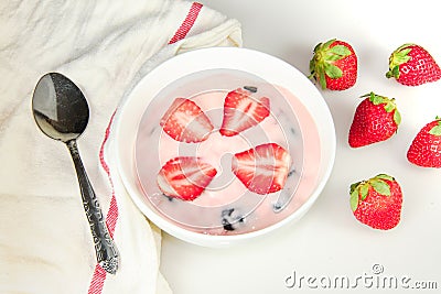 Strawberry Yogurt in the bowl on the white table Stock Photo