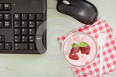 Strawberry yogurt on desk with mount keyboard Stock Photo