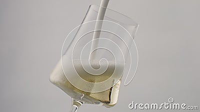 Stream champagne foam pouring to glass goblet in super slow motion close up. Stock Photo