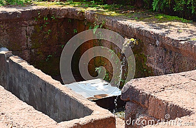 Stream of Water coming out of Cow Mouth Gomukh in an Ancient Hindu Temple, Karhateshwar Shiva Temple Stock Photo