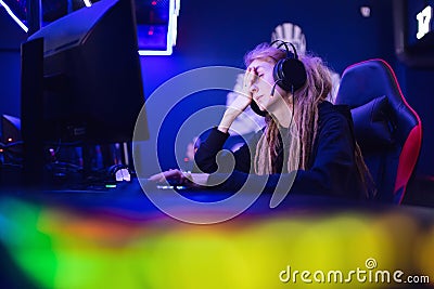 Streamer beautiful girl regrets losing professional gamer loser playing online games computer, neon color Stock Photo