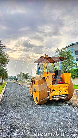 The streamroller is leveling the rocks for road repairs Stock Photo