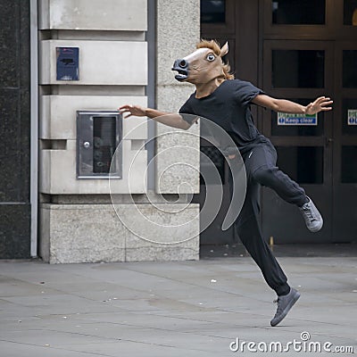 A street actor with a head-mounted horse dancing on the street Editorial Stock Photo