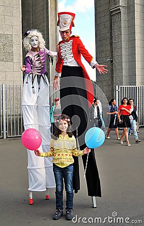 Street actors walk on stilts and pose for photos in Moscow Editorial Stock Photo