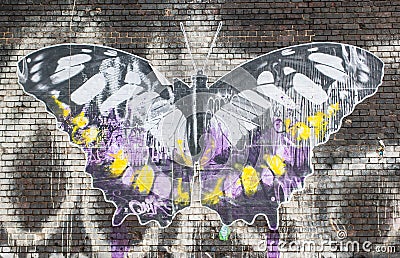Street art in London:artwork representing a big butterfly on a brick wall. Editorial Stock Photo