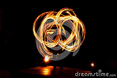 Street artist fire juggling performance. Light painting and long exposure picture to form trails. Phi Phi Island, Thailand. Stock Photo