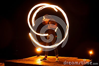 Street artist fire juggling performance. Light painting and long exposure picture to form trails. Phi Phi Island, Thailand. Editorial Stock Photo