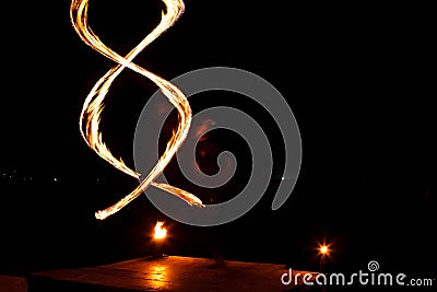 Street artist fire juggling performance. Light painting and long exposure picture to form trails. Phi Phi Island, Thailand. Stock Photo