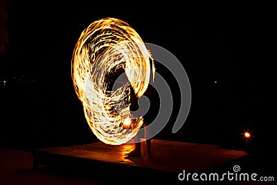 Street artist fire juggling performance. Light painting and long exposure picture to form trails. Phi Phi Island, Thailand. Stock Photo