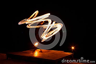 Street artist fire juggling performance. Light painting and long exposure picture to form trails. Phi Phi Island, Thailand. Stock Photo