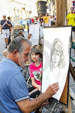 Street artist is making a portrait sketch of a young tourist Editorial Stock Photo