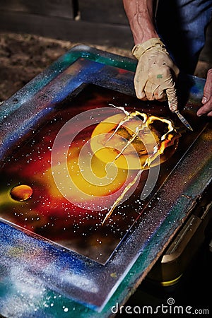Street artist painting on the canvas with aerosol paints. Editorial Stock Photo