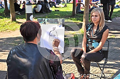 Street artist paints a portrait of a girl. Editorial Stock Photo