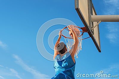 Street basketball athlete performing slam dunk on the court Stock Photo